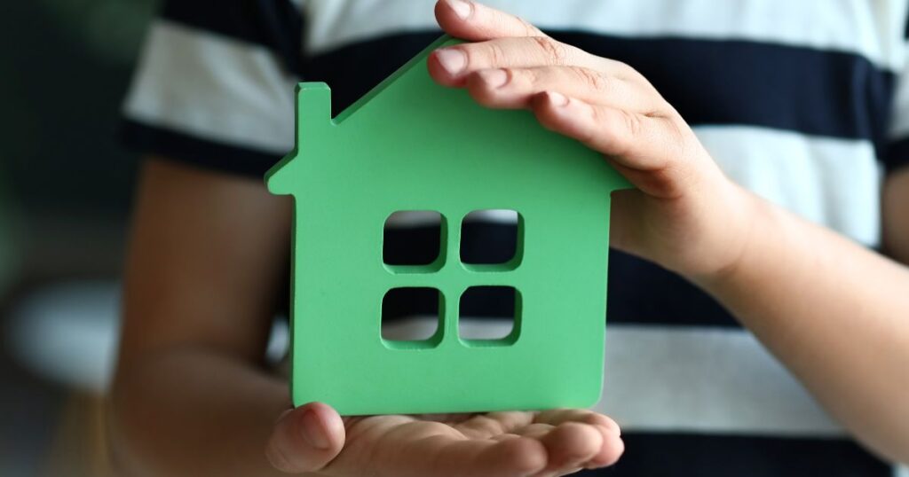 家の模型を手で支える