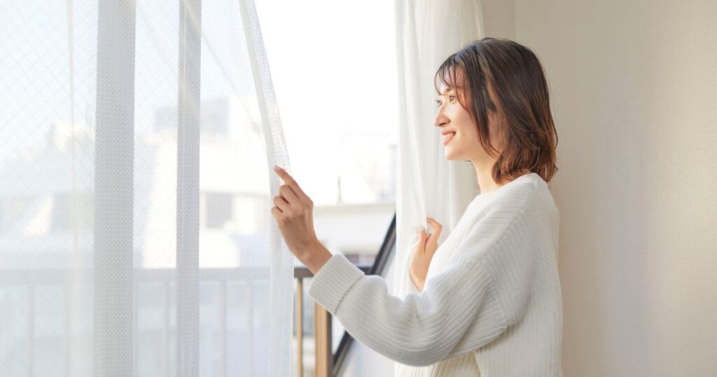 窓を開ける女性